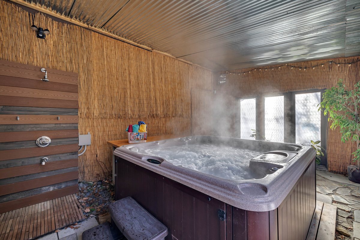 Covered hot tub room at Waterfall Wonder for indoor-outdoor cabin downtime.