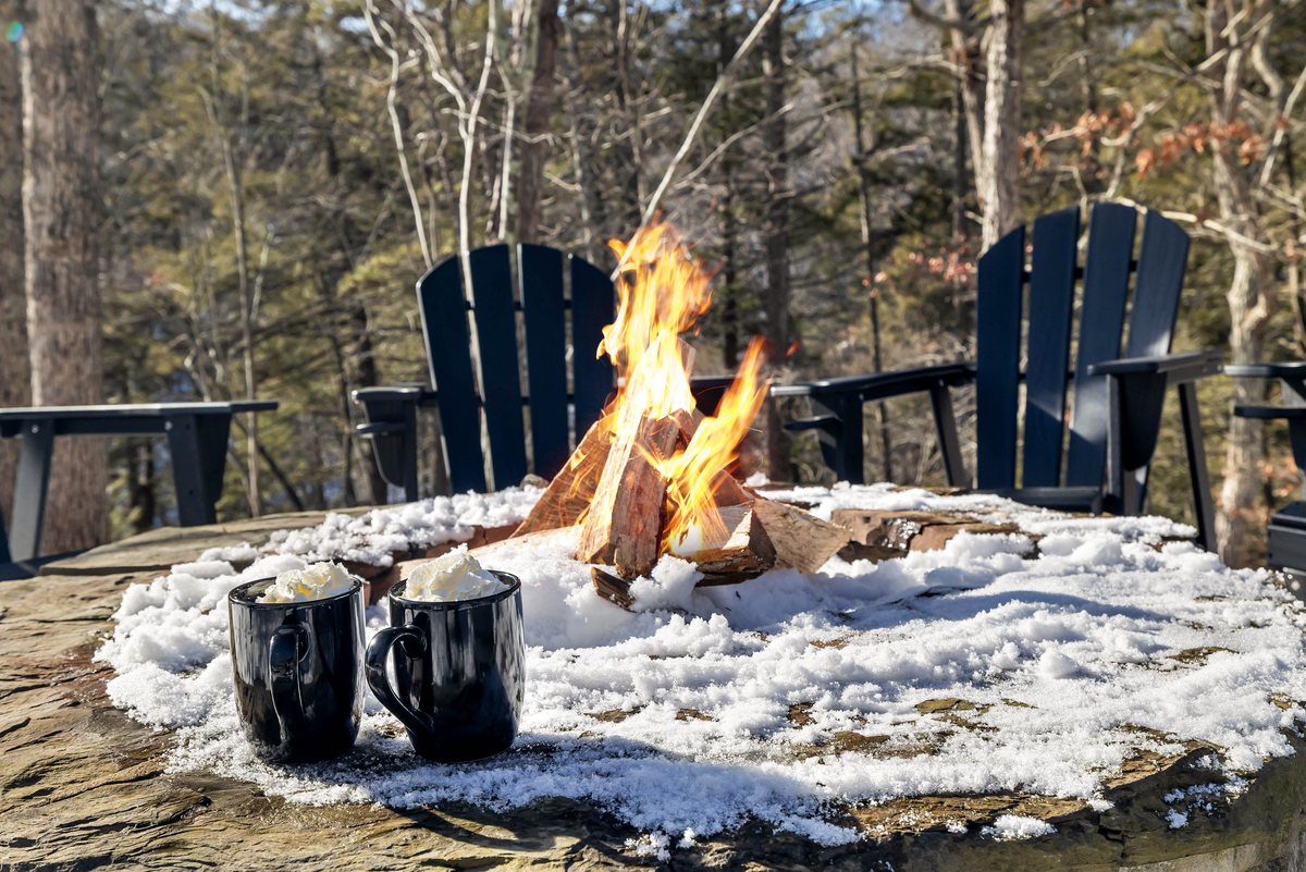 Fire pit seating at Waterfall Wonder with chairs, blankets, and winter woods.