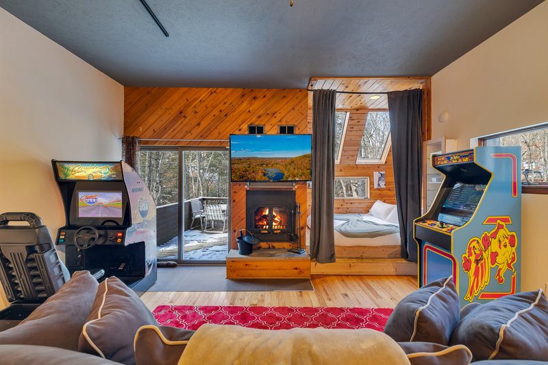 Game room at Waterfall Wonder with arcade-style entertainment and fireplace.