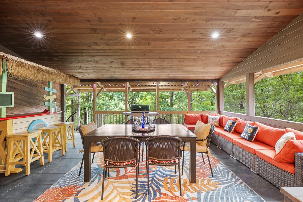 Screened deck dining area with forest views.